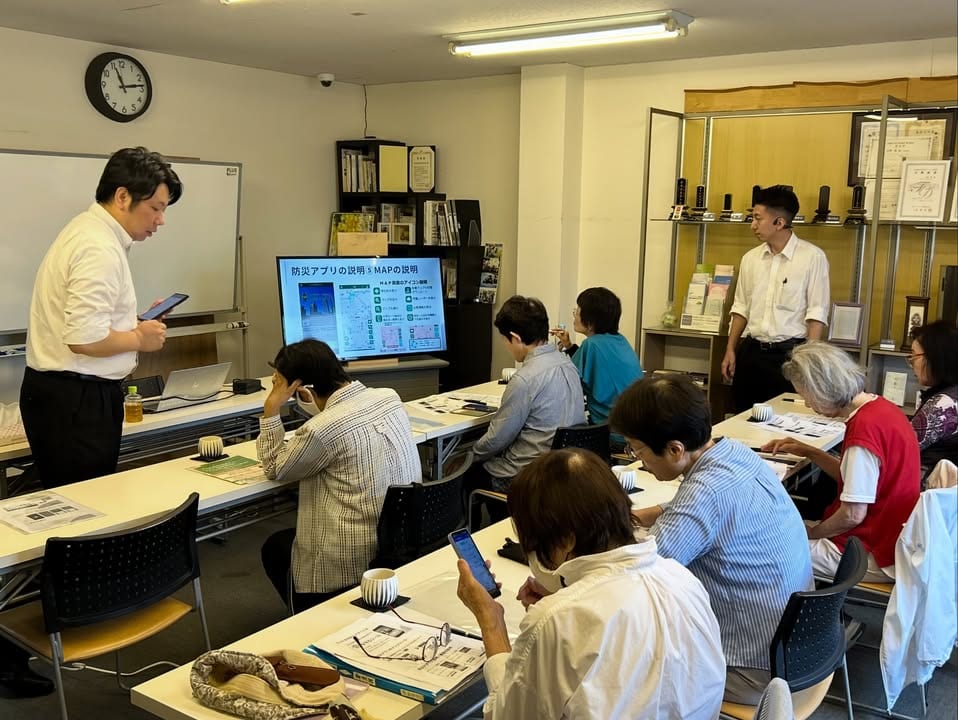 参加者のスマートフォン操作を講師がそばで案内する、過去のスマホ教室の様子